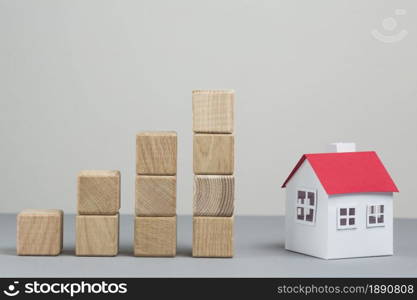 small house model stack increasing wooden block grey backdrop. Resolution and high quality beautiful photo. small house model stack increasing wooden block grey backdrop. High quality and resolution beautiful photo concept
