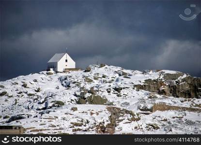 Small house perched on top of snow covered mountain