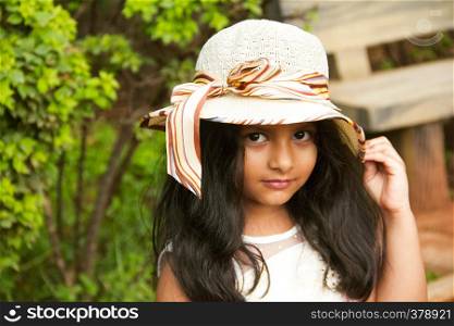 Small Indian girl wearing round fancy cap looking at camera, Pune. Small Indian girl wearing round fancy cap looking at camera, Pune.