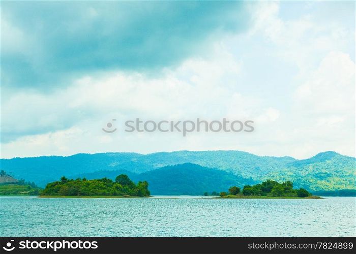 Small island in the middle of the lake. The back is a complex mountain forests.