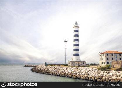 Small lighthouse in Lido de Jesolo in cloudy weather at the sea passage
