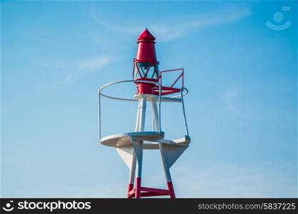 Small lighthouse on blue sky in daylight