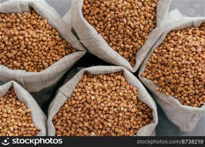 Small linen bags filled with raw buckwheat for your healthy eating. Agriculture and farming. Uncooked buckwheat. Dietary product