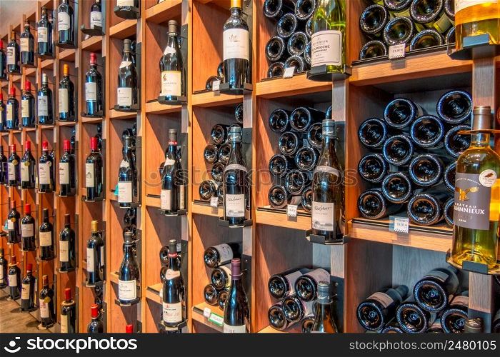 Small liquor store in Paris. Many white and red wines on the shelves. French Wine Shop Shelves