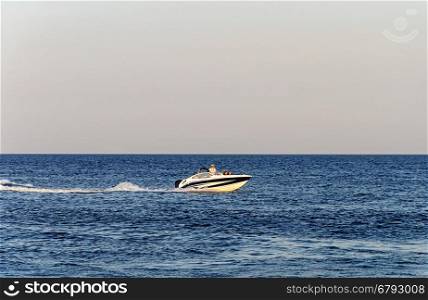 Small motor boat with tourists in the Black Sea near Odessa, Ukraine. Summer evening.