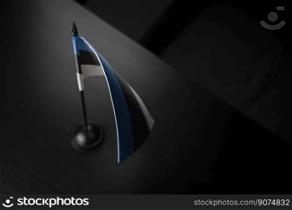 Small national flag of the Estonia on a black background.. Small national flag of the Estonia on a black background