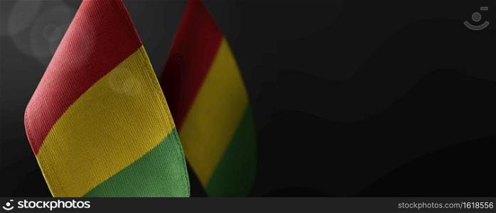 Small national flags of the Guinea on a dark background.. Small national flags of the Guinea on a dark background