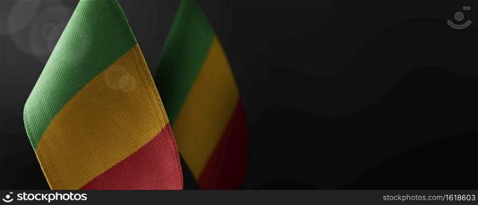 Small national flags of the Mali on a dark background.. Small national flags of the Mali on a dark background