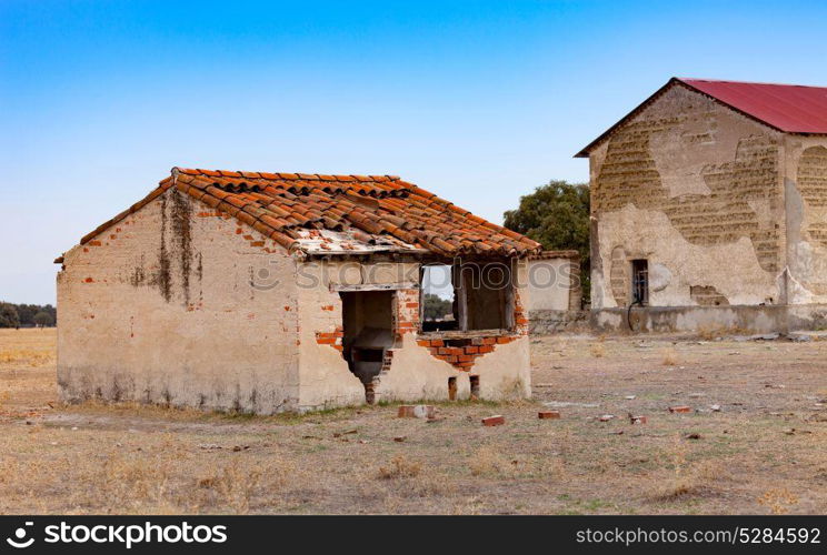 Small old house with the roof collapsed and a broken window