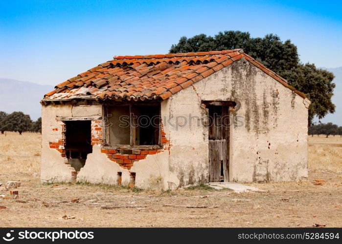 Small old house with the roof collapsed and a broken window