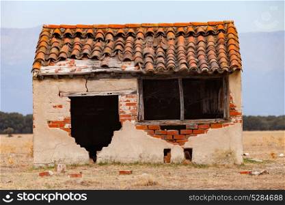 Small old house with the roof collapsed and a broken window