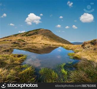 Small picturesque lake with clouds reflections at the  Strymba Mount. Beautiful autumn day in Carpathian Mountains near Kolochava village, Transcarpathia, Ukraine.