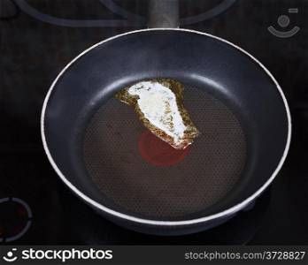 small piece dairy butter melting on hot frying pan on electric coocker