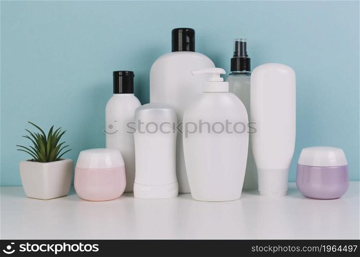 small plant near various cosmetics bottles. High resolution photo. small plant near various cosmetics bottles. High quality photo