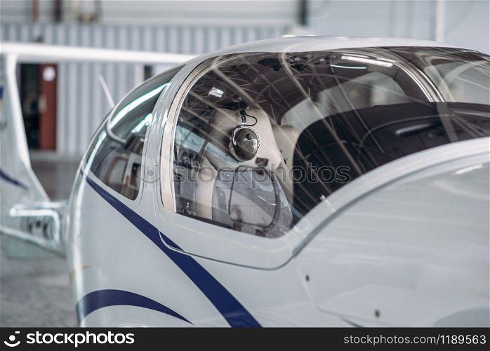 Small propeller plane in hangar, plane on inspection before flight. Private airline, air transportation, front view on turboprop airplane. Small propeller plane in hangar, private airline