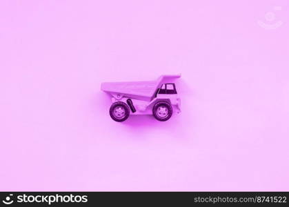 Small purple toy truck on texture background of fashion pastel purple color paper in minimal concept.. Small purple toy truck on texture background of fashion pastel purple color paper