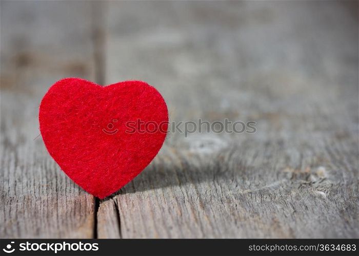 Small red heart on the old wooden floor.