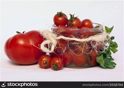 Small red tomatoes in a jar vs a normal-sized tomato