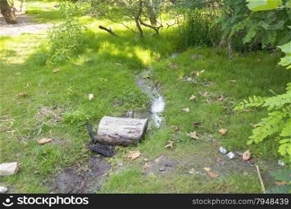 Small river flowing in the grass, horizontal image
