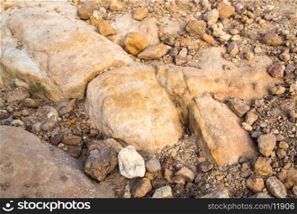 small rock formation in brown tones with lose rocks