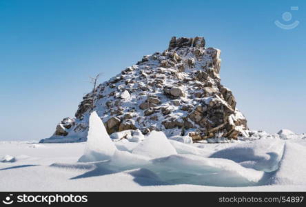 Small rocky island cover with snow in Frozen Lake Baikal, Russia