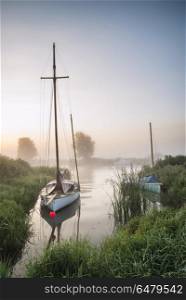 Small sailing boat moored on colorful River Thurne landscape dur. Landscapes. Small sailing boat moored on River Thurne landscape during sunrise in Summer