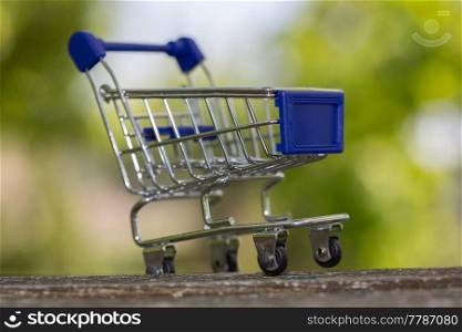 small shopping cart, studio picture on a wooden table