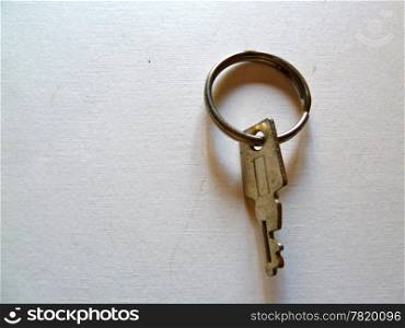 small silver key on a white background