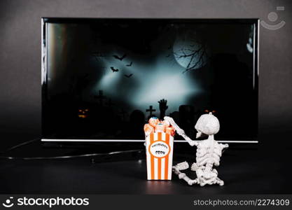 small skeleton with popcorn tv