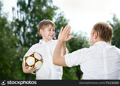 Small son - the football player welcomes the father, summer