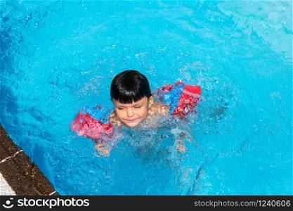 Small spanish boy swimming in pool. Summer vacation.