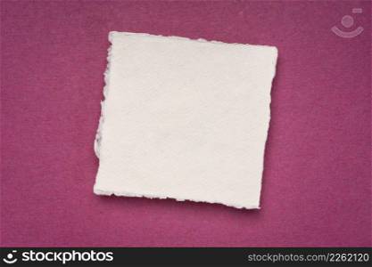 small square sheet of blank white Khadi paper against magenta rag paper