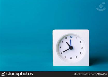 small square white clock on a yellow background