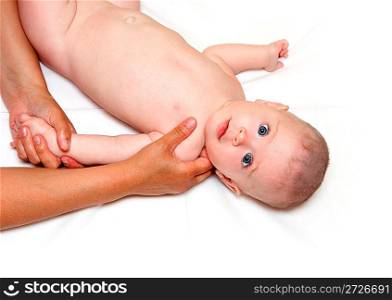 small staring baby massaging on white sheet