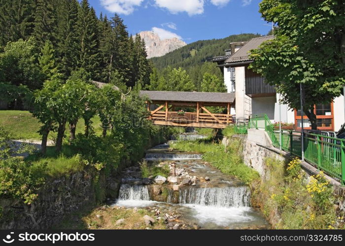 Small stream with amazing bridge in Canazei, Italy