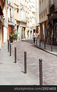 Small street with cobblestone pavement in historic center of Paris, France