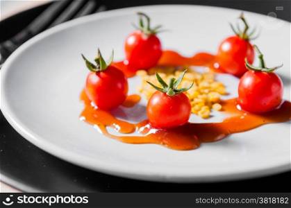 small tomato and beans on white dish of bio food stylish closeup