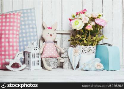 Small toy house, pony, toy bunny, pillows in the children&amp;#39;s room on wooden background
