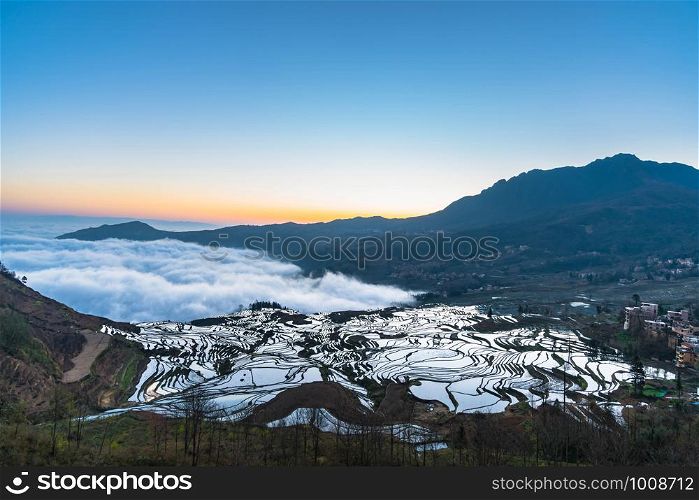 Small village and Terraced rice fields of YuanYang , China with sea of fog and cloud
