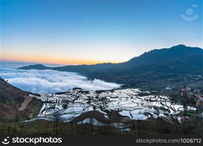 Small village and Terraced rice fields of YuanYang , China with sea of fog and cloud