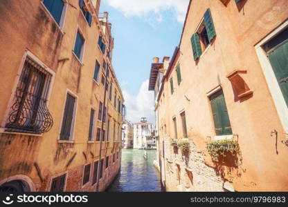 Small water passage in Venice, Italy with old buildings in the summer sun