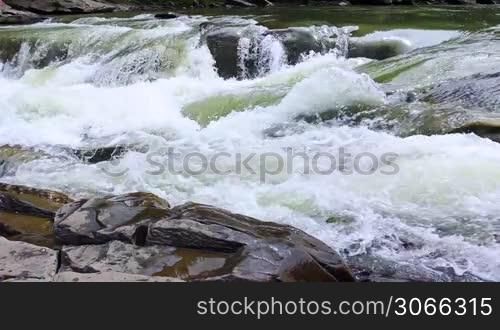 small waterfall and boiling water of mountain river
