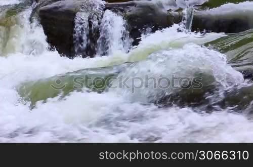 small waterfall and boiling water of mountain river, closeup