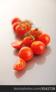 small wet fresh red tomato group isolated on white with glossy surface reflection