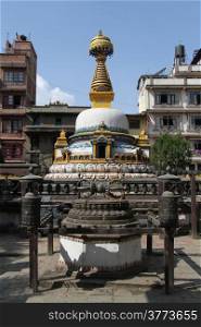 Small white buddhist stupa in the yard of residential distric of Patan, Nepal