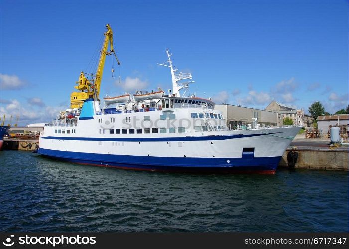 Small white passenger ferry costs in port