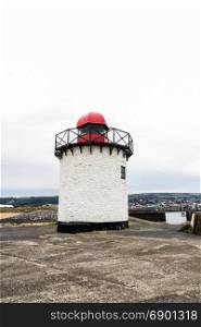 Small white squat white lighthouse with red top. Burry Port, Llanelli, Carmarthenshire, Wales.