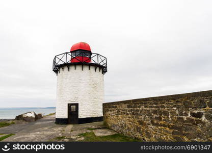 Small white squat white lighthouse with red top. Burry Port, Llanelli, Carmarthenshire, Wales.