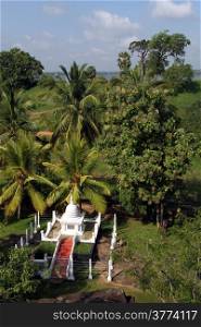 Small white stupa nd green palm trees in Anuradhapura, Sri Lanka