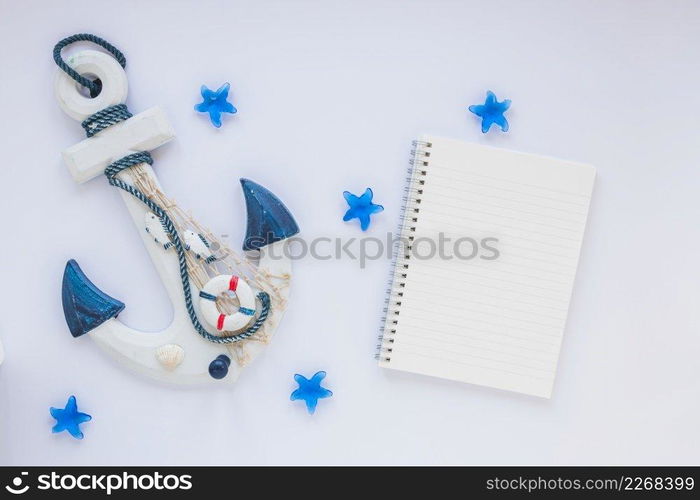 small wooden anchor with blank notebook